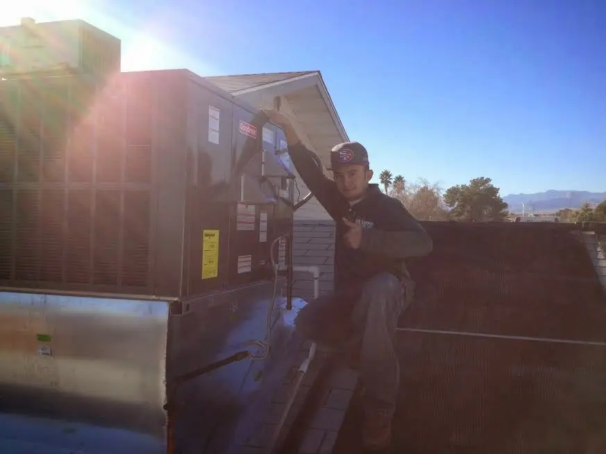 HVAC technician performing AC Tune-Up on a rooftop unit in Blaine